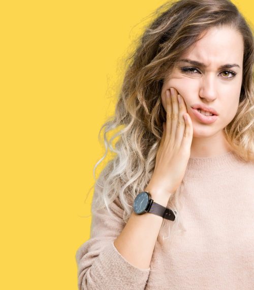 Beautiful young blonde woman wearing sweatershirt over isolated background touching mouth with hand with painful expression because of toothache or dental illness on teeth. Dentist concept.